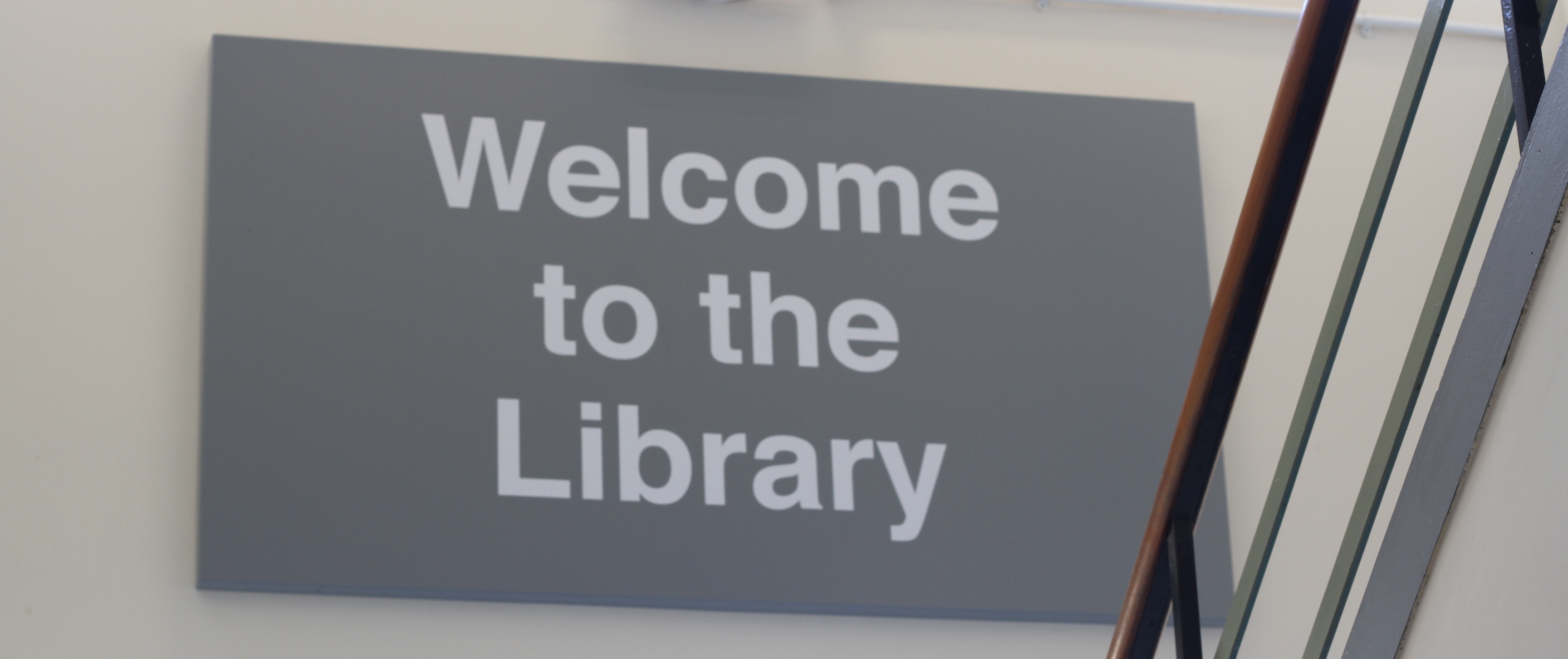 A grey sign which reads Welcome to the Library.